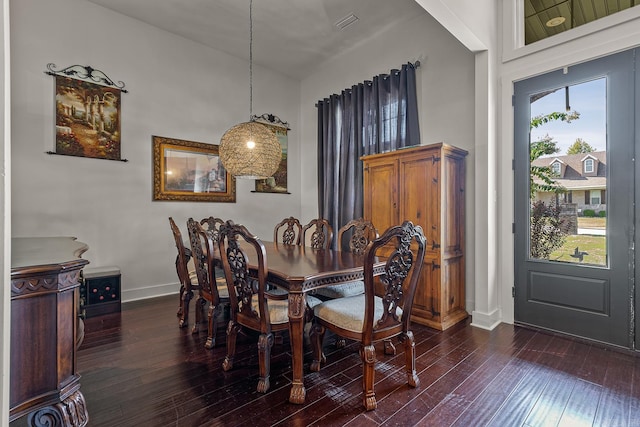 dining room with a healthy amount of sunlight, dark hardwood / wood-style flooring, and a high ceiling