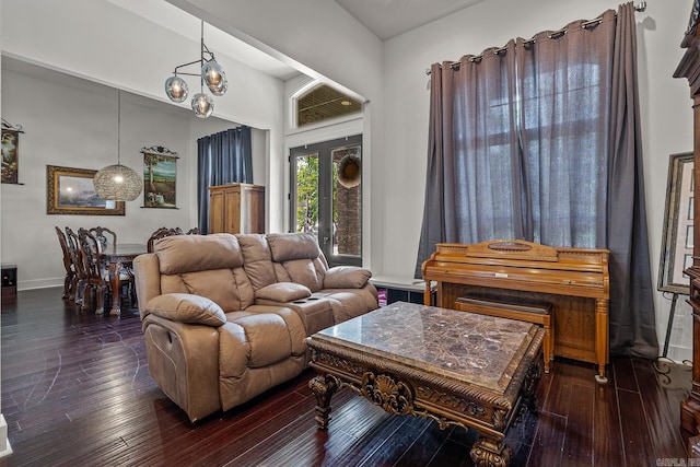 living room with dark hardwood / wood-style floors and a notable chandelier