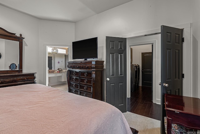 bedroom featuring washer and clothes dryer, ensuite bathroom, and wood-type flooring