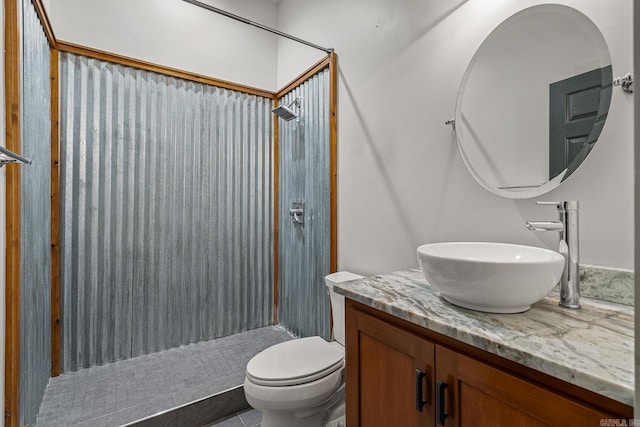 bathroom with tile patterned flooring, toilet, vanity, and walk in shower