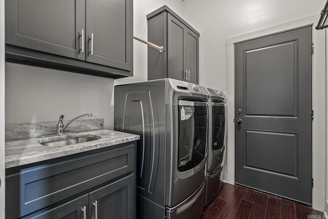 laundry area featuring cabinets, dark hardwood / wood-style floors, washer and clothes dryer, and sink