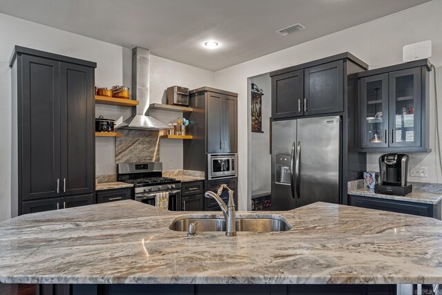 kitchen with sink, light stone countertops, a large island, island range hood, and stainless steel appliances