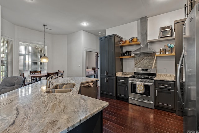 kitchen with appliances with stainless steel finishes, island range hood, sink, dark hardwood / wood-style floors, and hanging light fixtures