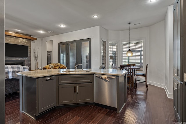 kitchen with dishwasher, an island with sink, pendant lighting, and sink