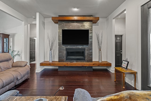 living room with dark hardwood / wood-style floors and a tile fireplace