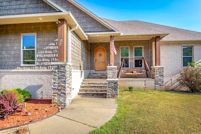 property entrance featuring a yard and covered porch