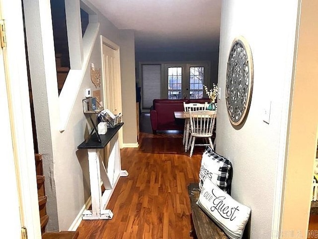 corridor with dark hardwood / wood-style floors and french doors