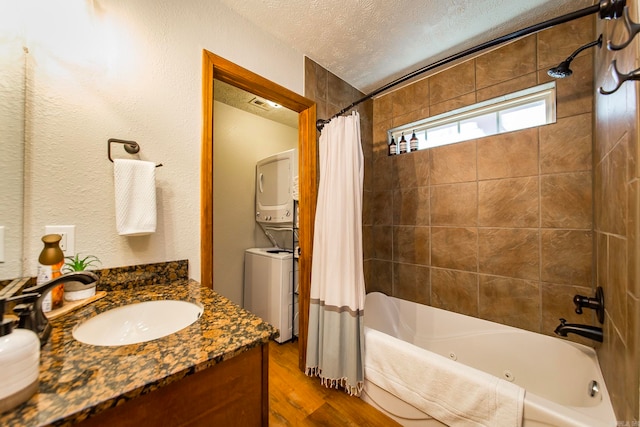 bathroom featuring shower / bath combo, a textured ceiling, vanity, and stacked washer and dryer