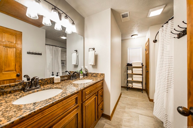 bathroom featuring a textured ceiling and vanity