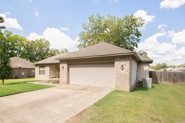 view of front of property with a garage, a front lawn, and central AC unit