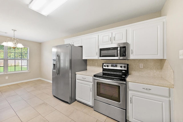 kitchen with an inviting chandelier, stainless steel appliances, and white cabinets