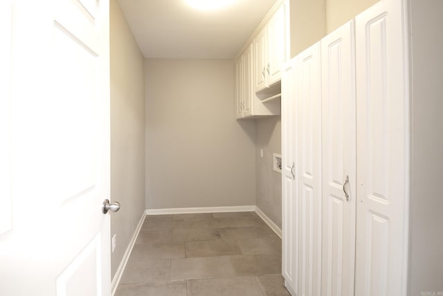 washroom with washer hookup, tile patterned flooring, and cabinets