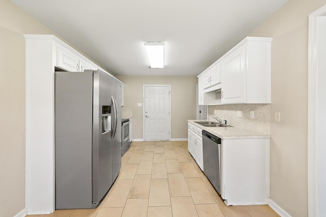 kitchen with sink, white cabinets, stainless steel appliances, backsplash, and light tile patterned floors