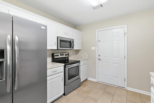 kitchen with white cabinetry, light tile patterned floors, appliances with stainless steel finishes, and tasteful backsplash