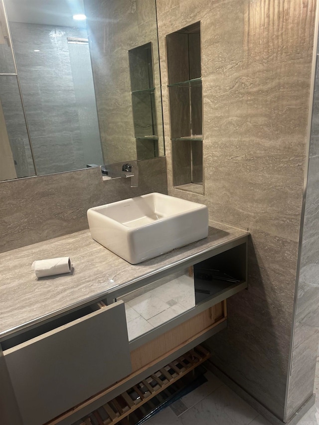 bathroom with vanity and tile walls