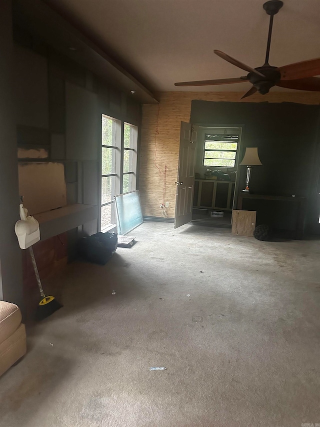 unfurnished living room featuring ceiling fan and plenty of natural light