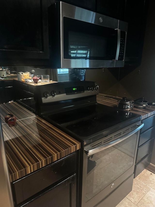 kitchen with light tile patterned flooring and appliances with stainless steel finishes