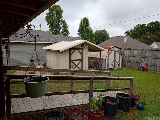 2804 Jerry Lee, Mena, AR 71953 - view of yard featuring an outdoor structure, a storage unit, a wooden deck, and fence
