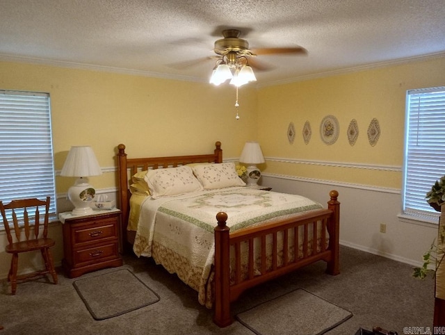 carpeted bedroom with ceiling fan, crown molding, and a textured ceiling