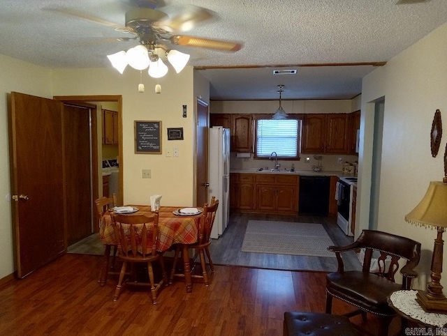 dining space featuring a textured ceiling, sink, ceiling fan, and dark hardwood / wood-style flooring