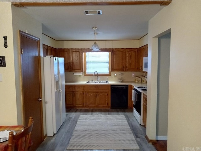 kitchen with white appliances, sink, pendant lighting, and dark hardwood / wood-style flooring