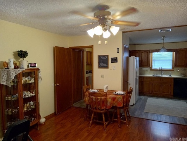 dining area featuring a textured ceiling, ceiling fan, dark hardwood / wood-style floors, and sink