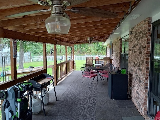 sunroom featuring ceiling fan and plenty of natural light