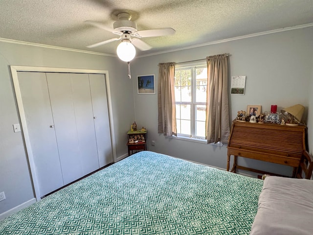 bedroom featuring ceiling fan, a textured ceiling, a closet, and ornamental molding