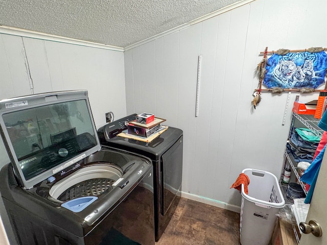 laundry area featuring a textured ceiling, wooden walls, and washer and dryer