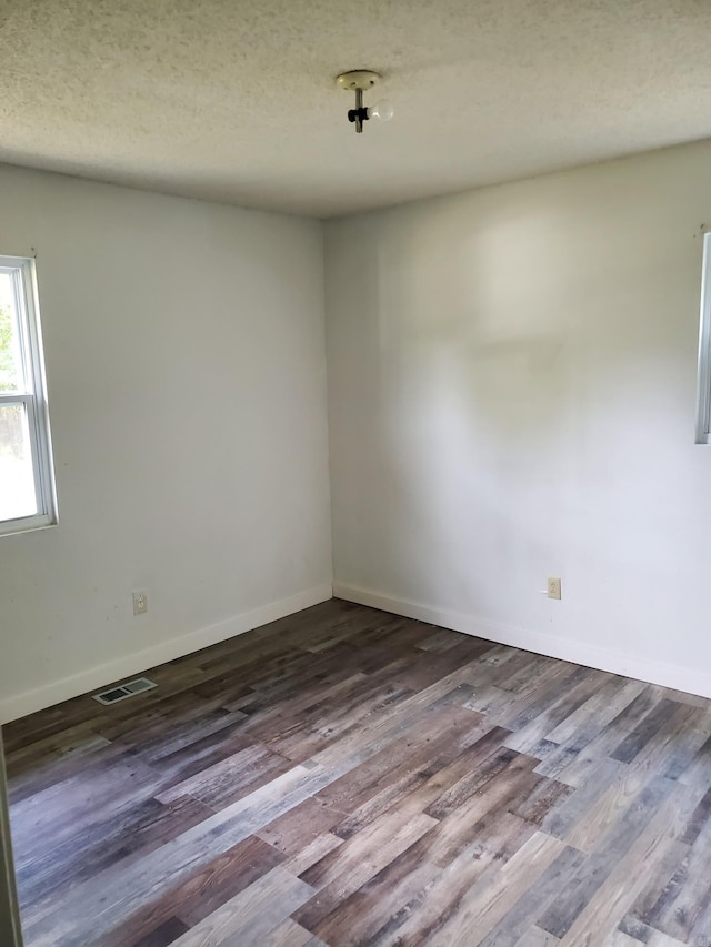 spare room with wood-type flooring and a textured ceiling