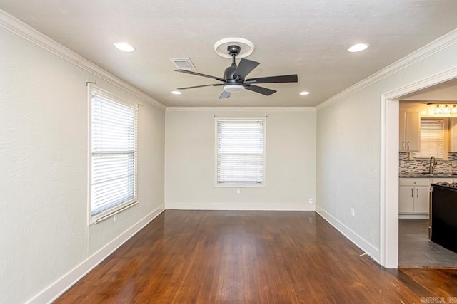 empty room with a wealth of natural light, ceiling fan, dark hardwood / wood-style floors, and sink