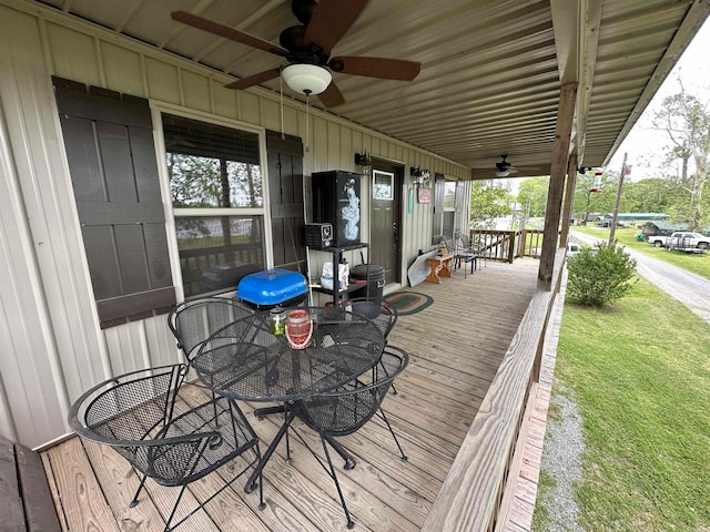 wooden deck featuring a yard and ceiling fan