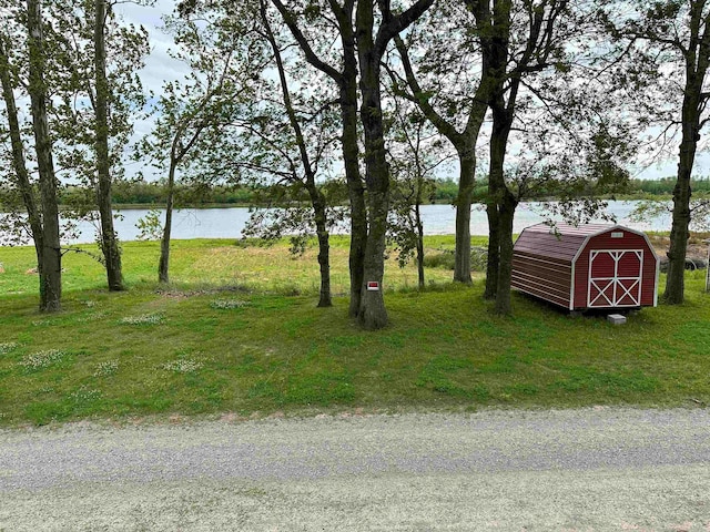 view of yard with a storage shed and a water view