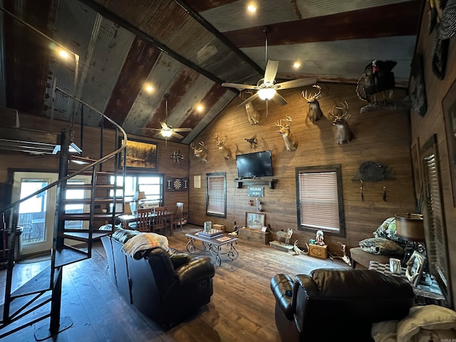 living room with high vaulted ceiling, wood walls, beam ceiling, ceiling fan, and hardwood / wood-style floors