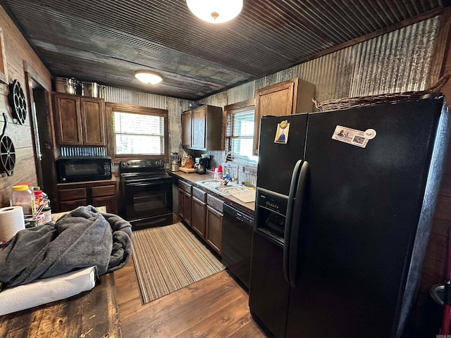 kitchen with light hardwood / wood-style flooring, black appliances, and sink