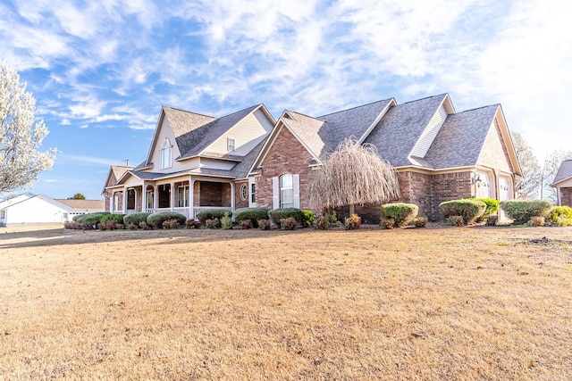 view of front of home featuring a front yard, a porch, and a garage