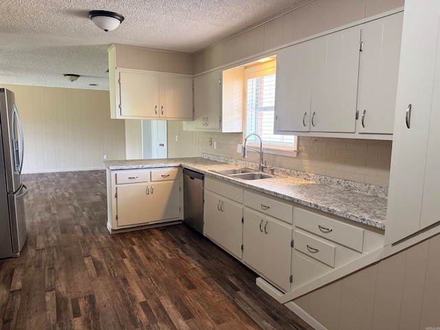 kitchen with dark hardwood / wood-style flooring, sink, kitchen peninsula, and appliances with stainless steel finishes