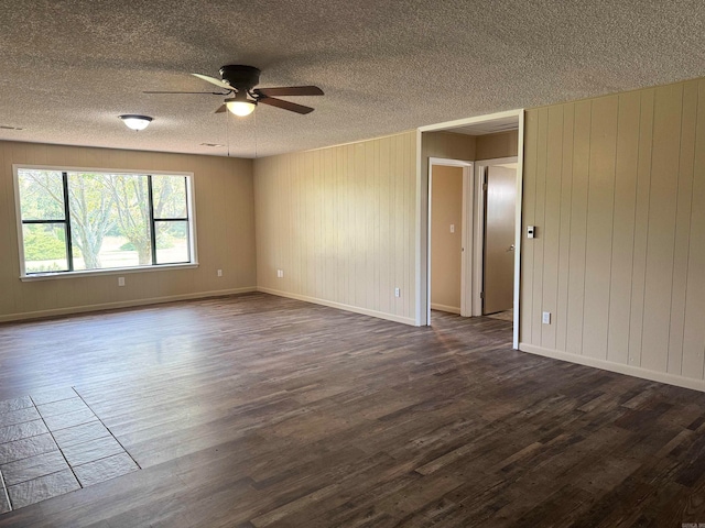 unfurnished room featuring ceiling fan, dark wood-type flooring, and a textured ceiling