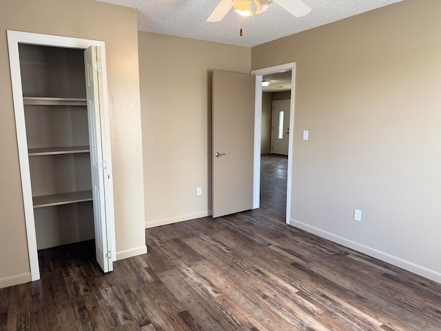 unfurnished bedroom with ceiling fan, dark wood-type flooring, a textured ceiling, and a closet