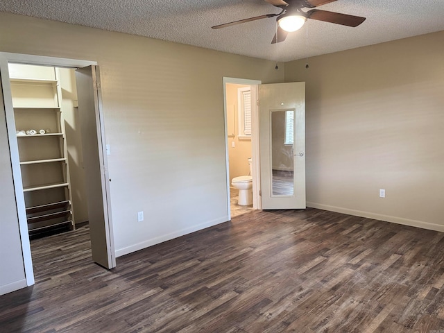 unfurnished bedroom with dark hardwood / wood-style floors, a textured ceiling, and a closet