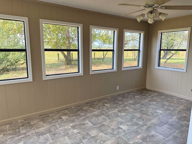 empty room with ceiling fan, ornamental molding, a textured ceiling, and a wealth of natural light