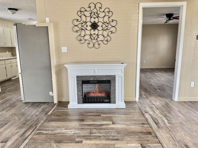 details featuring ceiling fan, hardwood / wood-style floors, stainless steel fridge, and a textured ceiling