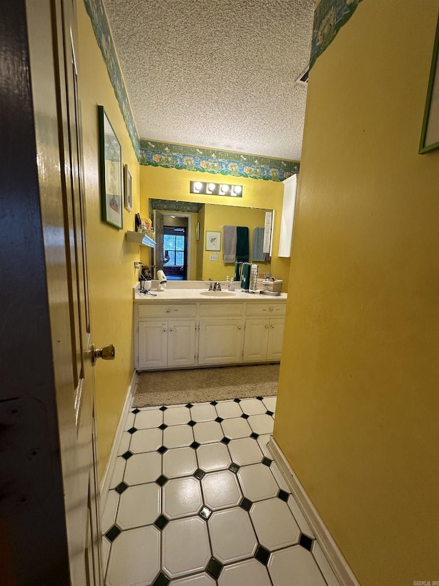 3409 Ramsgate, Fort Smith, AR 72908 - bathroom featuring double vanity, baseboards, a sink, and a textured ceiling