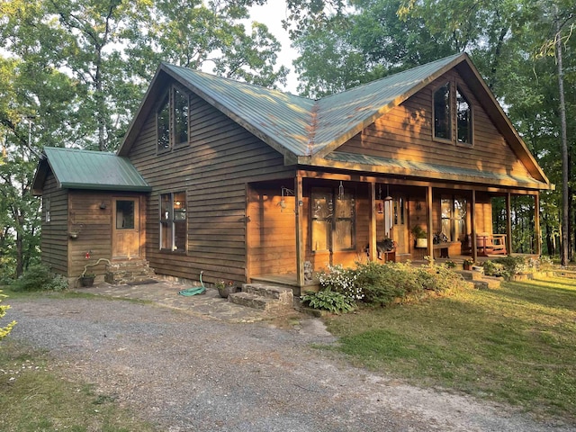 log cabin featuring a front lawn and a porch