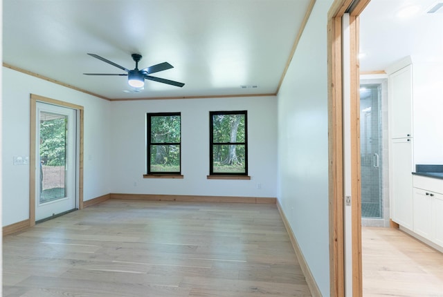 unfurnished room with light hardwood / wood-style floors, crown molding, and ceiling fan