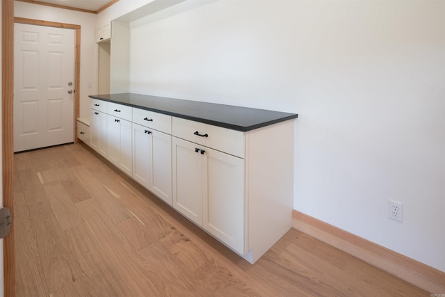 hall featuring ornamental molding and light hardwood / wood-style floors