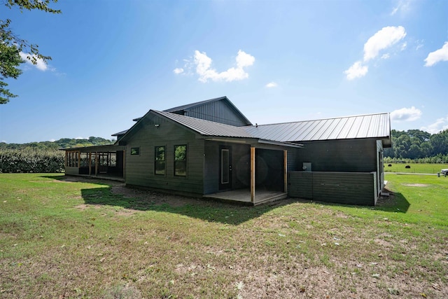 back of house with a patio and a lawn