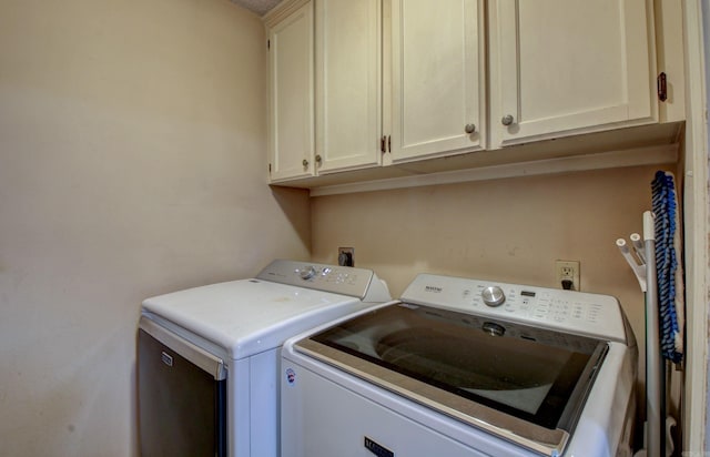 laundry area featuring washer and dryer and cabinets