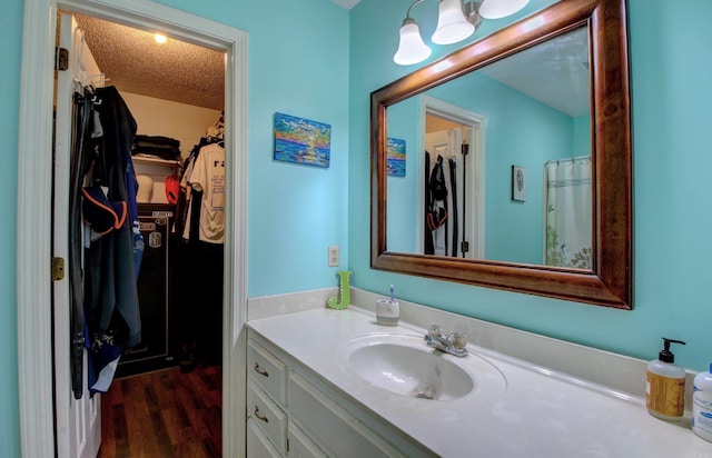 bathroom featuring wood-type flooring, a textured ceiling, and vanity