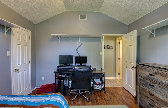 bedroom featuring a textured ceiling, lofted ceiling, and dark hardwood / wood-style flooring